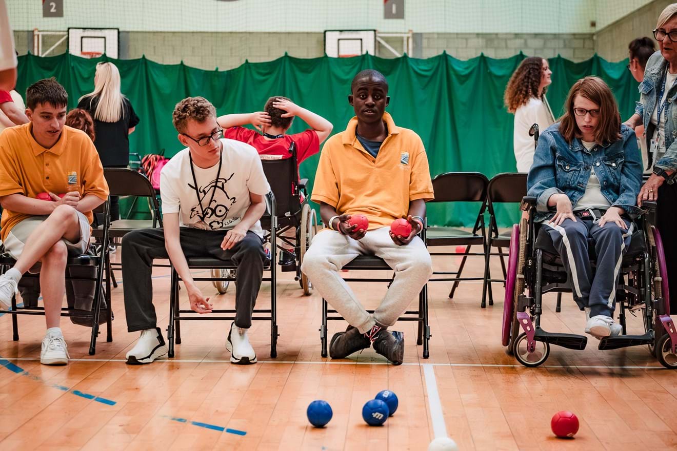 Young people playing boccia inside a hall
