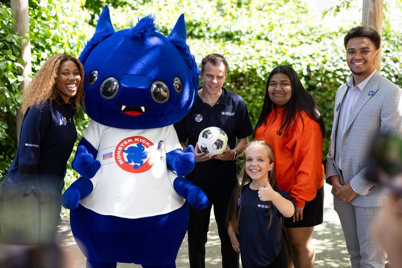 Group of people with monster mascot smiling at camera